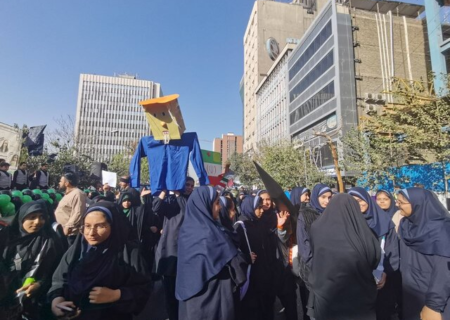 آدمک ترامپ در دست دانش‌آموزان شرکت کننده در راهپیمایی ۱۳ آبان